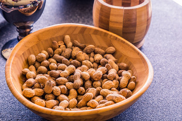 A lot of peanuts are a tasty and fresh snack. Natural and healthy nuts are full of vitamins and oils. They lie in a wooden bowl in the store and on the market.