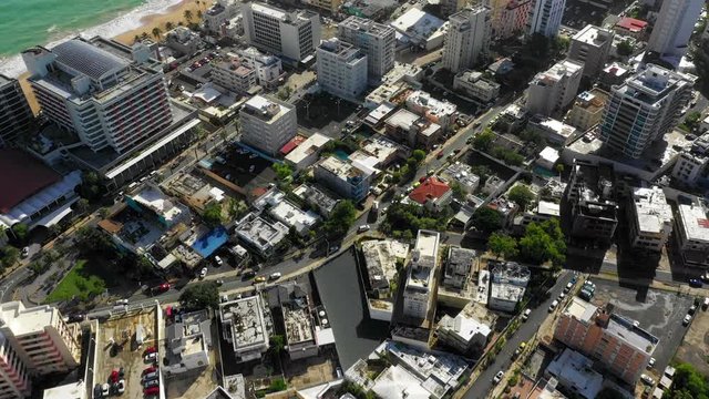 Forward aerial drone shot that shows the Laguna del Condado area of San Juan, Puerto Rico till the beach.
