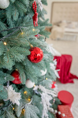 Gifts under decorated christmas tree with red balls. Close up