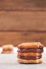 Cookies with layers of chocolate filling on a wooden background, vertical image, copy space.