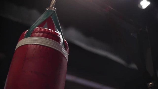 Punching bag swinging in boxing gym