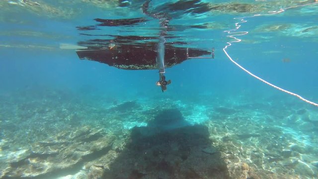 Coque de bateau et l'h&eacute;lice de son moteur vus en plong&eacute;e sous-marine