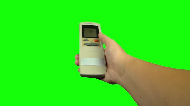 Hand using air conditioner controller to change the temperature. Green screen
