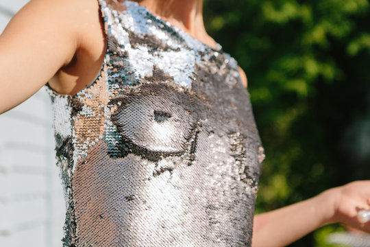 Woman in a sequin dress with breasts drawn on it