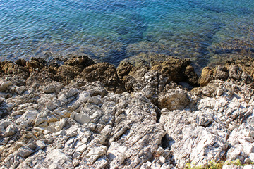 Clear blue sea water shoreline with rocks background