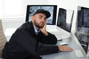 Male security guard sleeping at workplace indoors