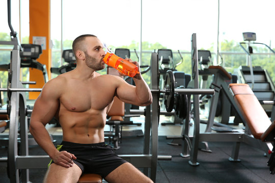 Portrait of athletic man drinking protein shake in gym