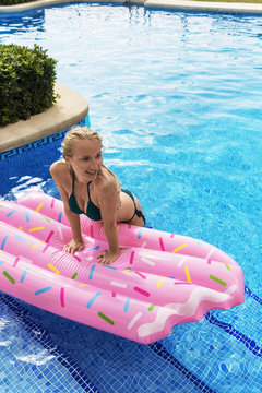 Pretty woman with airbed in pool