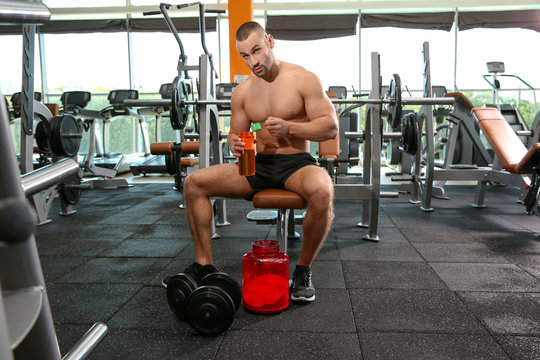 Portrait of athletic man preparing protein shake in gym