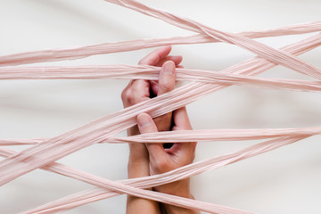 folded hands caught under silk ribbon