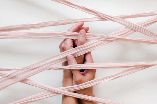 folded hands caught under silk ribbon