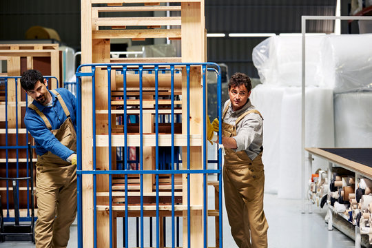 Colleagues Pushing Trolley With Wooden Frames
