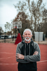 Portrait of a senior sportsman. Arms crossed, looking at camera.