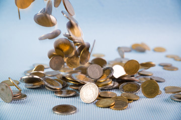 Falling coins money on blue background, business wealth concept.