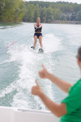 young woman learning to water skiing on a lake