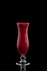 Glass of red strawberry fresh shake isolated at black background.