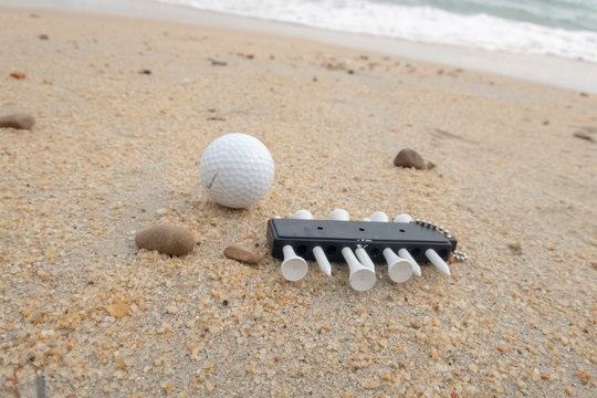 Golfer goes holiday at beach with golf ball and tee