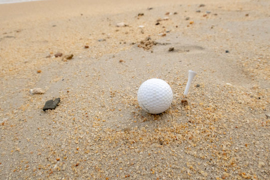 Golfer is on holiday at beach seaside with golf ball and tee