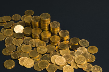 Savings, increasing columns of coins, piles of coins arranged as a graph in dark room, business banking concept.