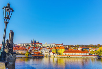 City view from bridge and traditional Czech architecture of antique Prague buildings at autumn evening.