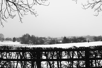 Closeup of black and white  photo of  wooden fence landscape in a countryside in wintertime with snow