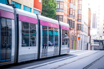 Naklejka na ściany i meble Closeup of pink new Modern Metro train traveling in the city in a sunny day