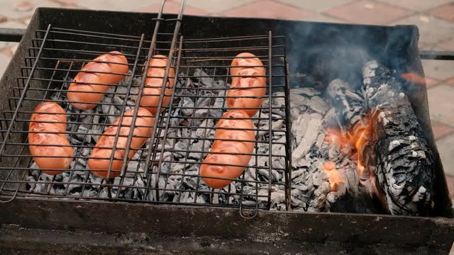 Grilling Sausages On Barbecue Grill. Pork Sausages Grilling On A Portable Bbq
