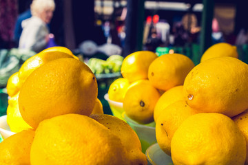 Closeup of row of Yellow sour lemons fruit in box in the grocery market in morning time, eating healthy food