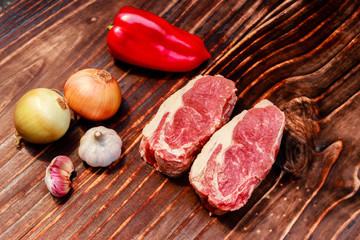 cuts of steak with also ingredients, onion, garlic and red pepper