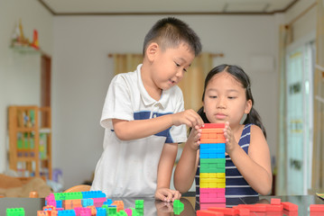 sister and brother play wood brick,