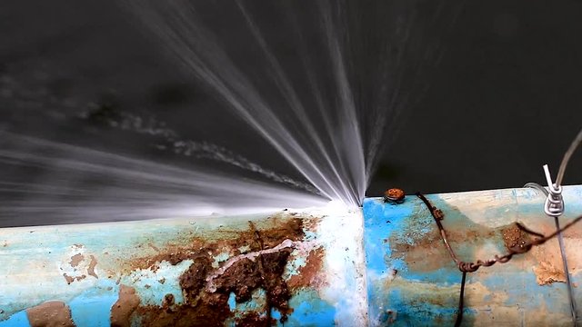 Large leaking blue mains water pipe in Chiang Rai Thailand