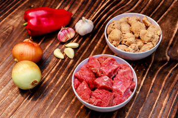 Two containers, one with beef in pieces and the other with soybeans also in pieces, also seasoning, onion, garlic and red pepper
