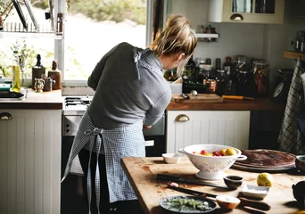 Crédence de cuisine en verre imprimé Cuisinier Woman preparing dinner in the kitchen