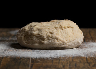 Studio photo of a ball of bread close-up and flour on table