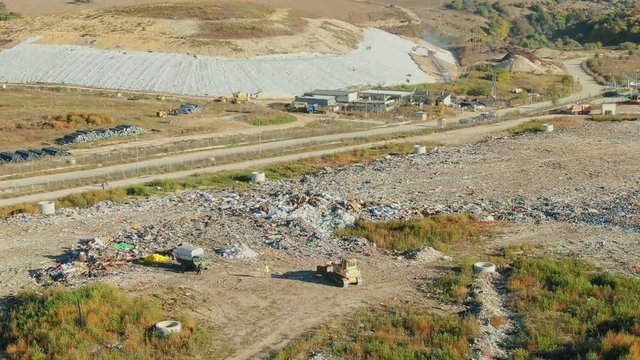 City Dump, The Bulldozer Moves garbage Along the Landfill, Leveling the rubish. AERIAL, Top Vew