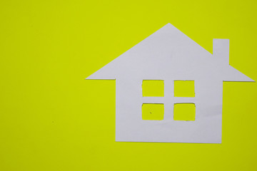 Concept of house in paper on yellow background. Horizontal composition. Top view.