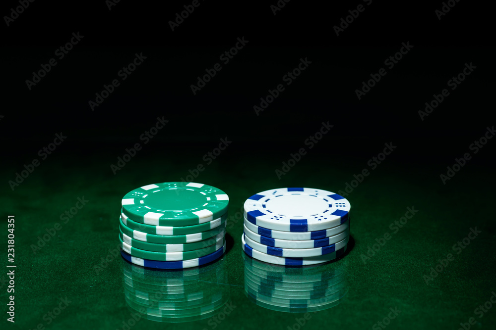 Wall mural casino games concept,poker chips on gamble table , light through background, winning hands of cards.