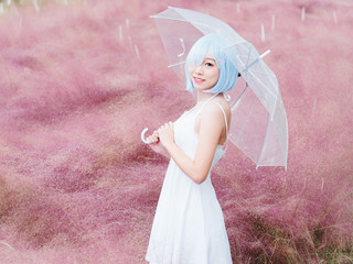 Portrait of beautiful young Chinese woman wearing white halter dress, holding transparent umbrella,...
