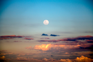 Full moon rising above the clouds