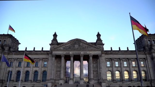 Reichstag, Berlin, Sunset reflecting in windows, people casually passing by