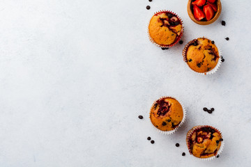 Strawberry chocolate cupcakes muffins on  concrete white light background. Top view.