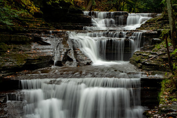 Fototapeta na wymiar Waterfall drapes the rocks in gorge.