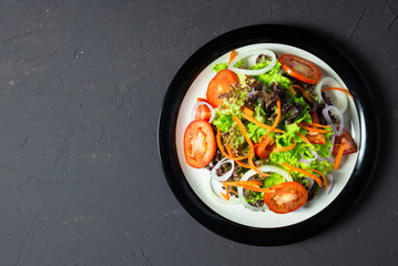 vegetable salad tomato, carrot, onion, spinach, and lettuce on black board