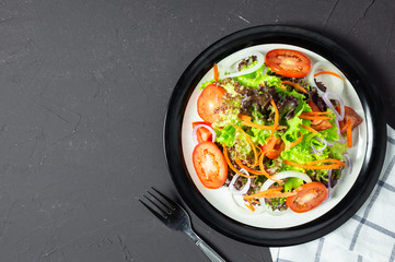 vegetable salad tomato, carrot, onion, spinach, and lettuce on black board
