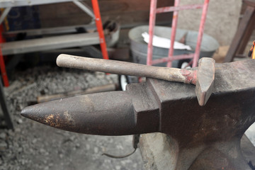 Blacksmith anvil and hammer in workshop
