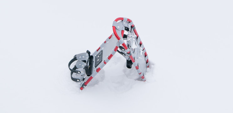 a pair of dimensionless snowshoes standing on white, fluffy snow