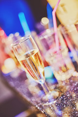 champagne wine drinks glasses on bar counter with bottles on background
