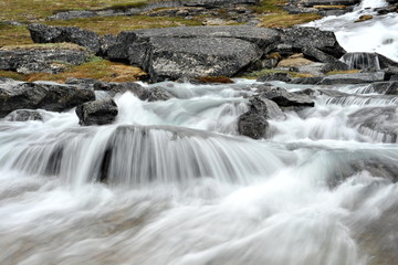 Waterfall on a mountain glacier river.