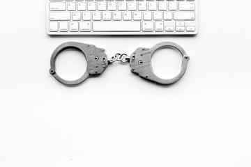 Cyberfraud concept. Handcuff near keyboard on white background top view space for text