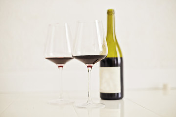 Red wine drinks in glasses with bottle on white background
